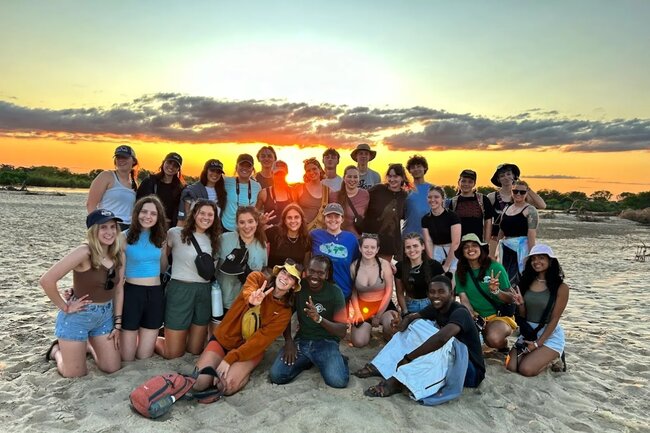 A group of friends on a beach during sunset